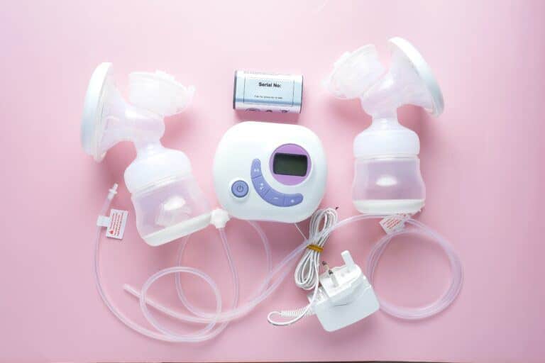 Breast pump parts displayed on pink background