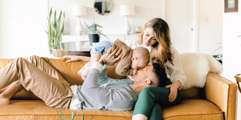 dad laying on moms lap, playing with newborn above his head - essay on the man i married