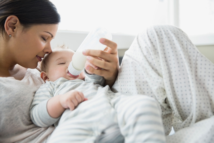 a woman feeding a baby