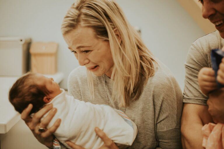 Mother crying while holding a baby