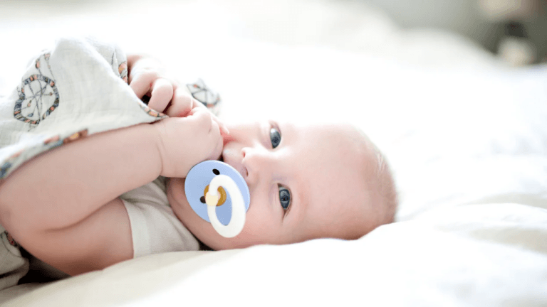 baby laying on its back with a pacifier