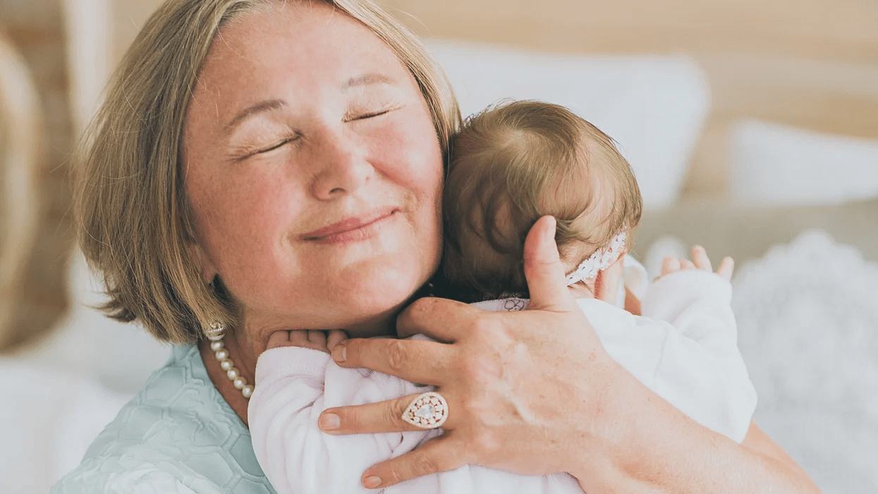grandma hugging newborn baby