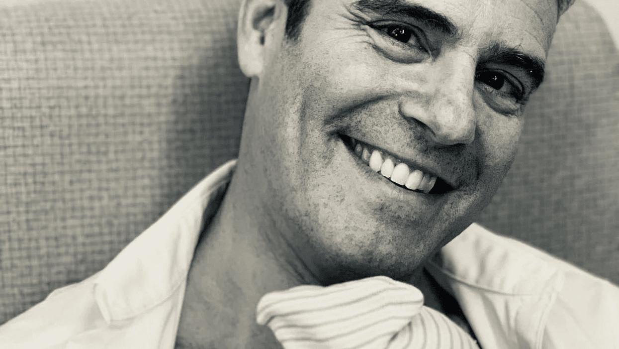 black and white photo of Andy Cohen holding his new baby