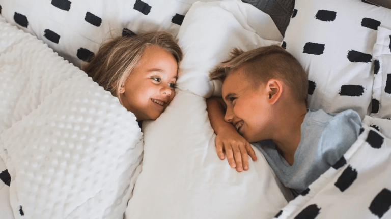 siblings giggling in bed