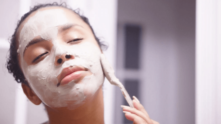 woman using an applicator to put on a face mask