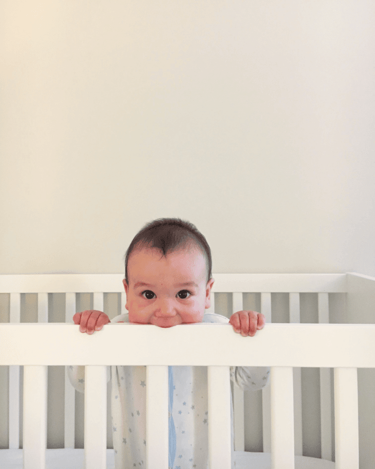 baby chewing on a crib