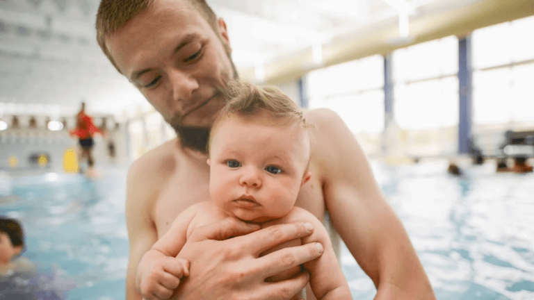 dad holding baby in a pool