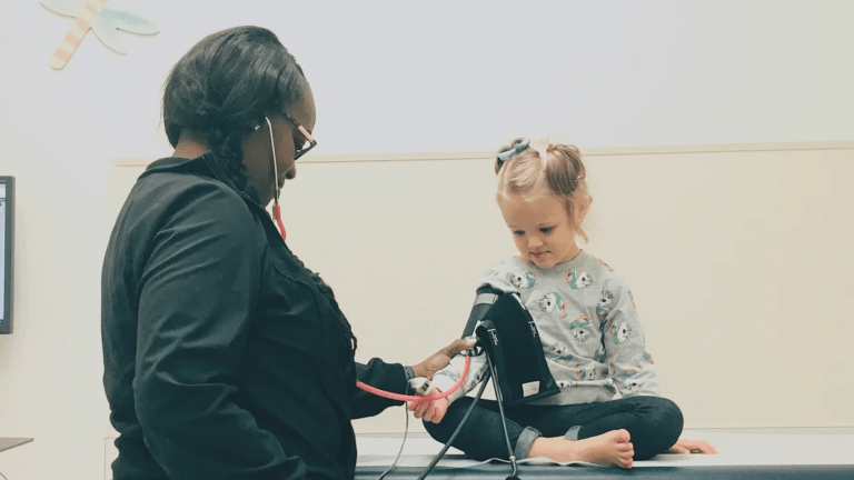 doctor checking out a little girl at the pediatricians office