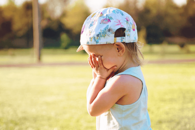 little girl crying into her hands