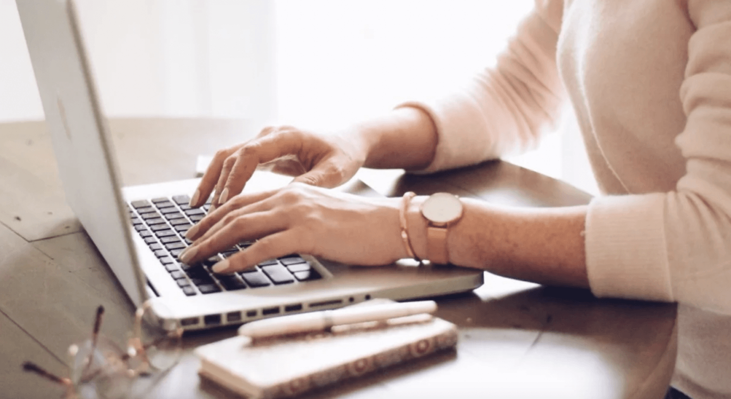 woman working on a computer wearing a bracelet and a watch