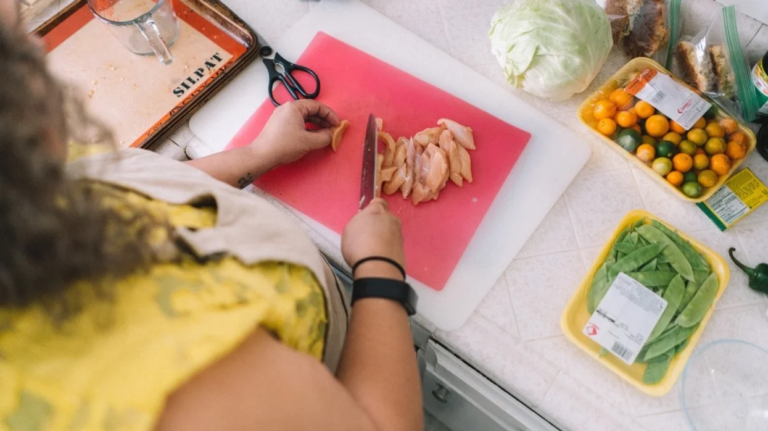 mom cutting chicken on a cutting board