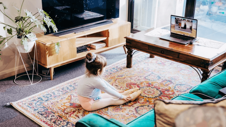 little girl doing ballet in front of a tablet