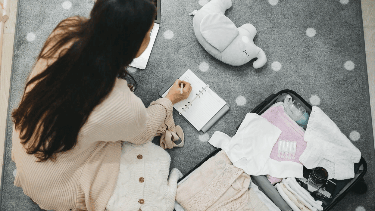 Woman packing diaper bag in maternity hospital. Stock Photo by