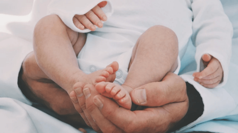 baby feet in father hands