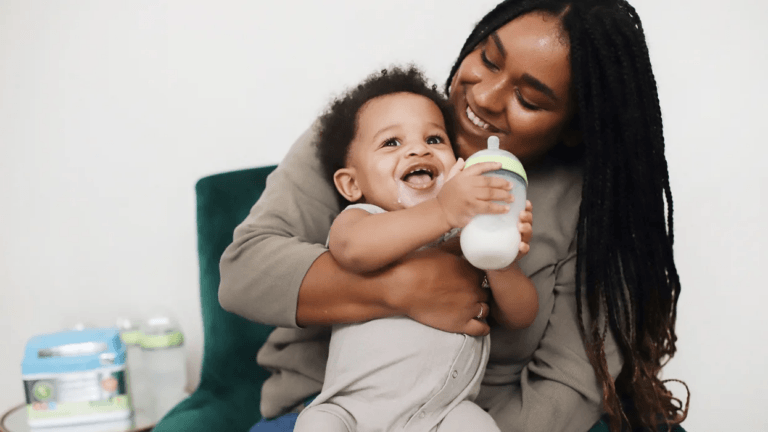 mom giving a baby a formula bottle