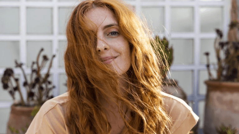 woman with red hair looking at the camera