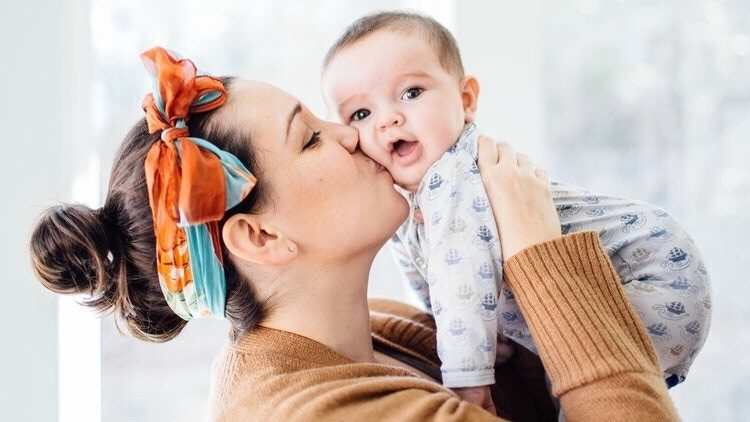 mom kissing baby on the cheek