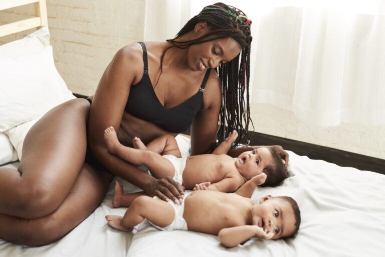 Mom wearing nursing bra and playing with her twins on a bed - best stylish nursing bras