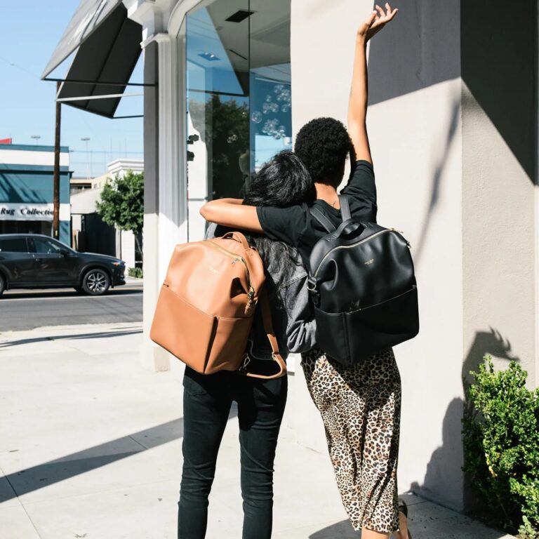 two women wearing backpacks