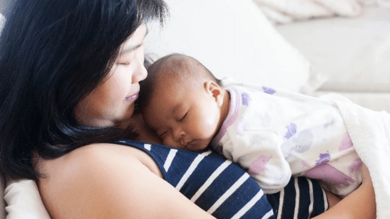 mom holding sleeping baby on her chest