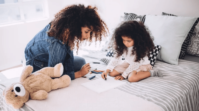 mom drawing with child on the bed