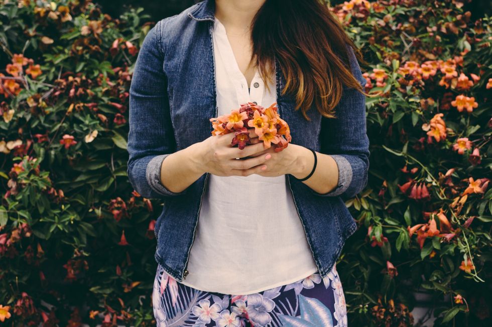 Woman holding small bouquet of flowers - questions to ask at preconception checkup