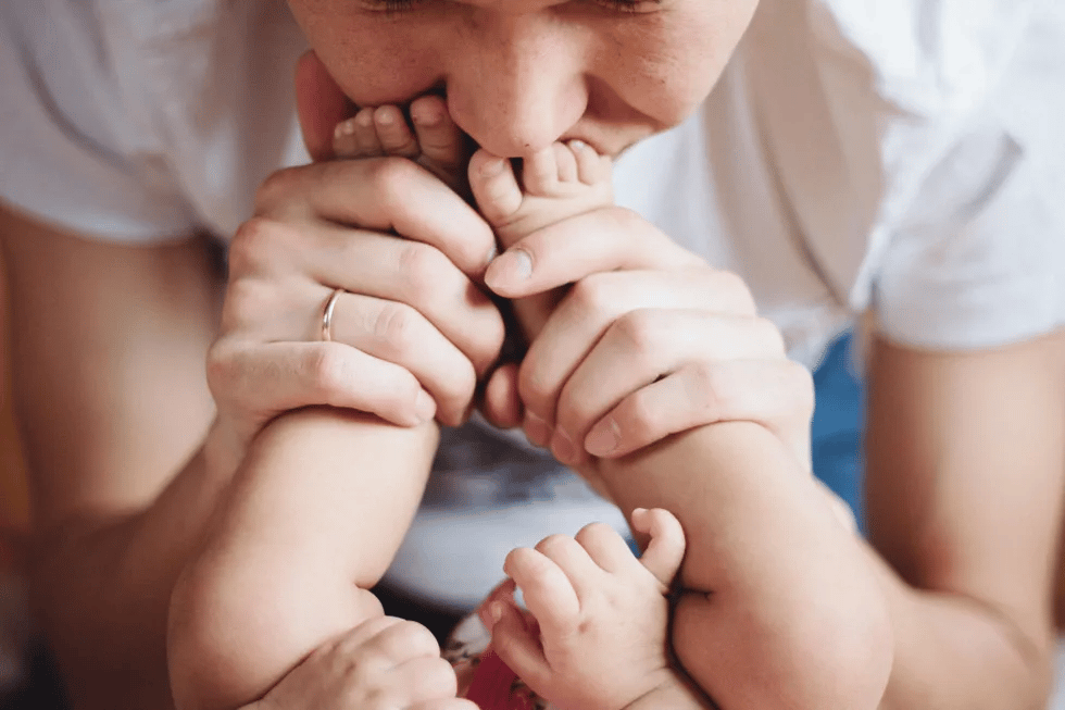 mom kissing baby's toes - 3 month milestones