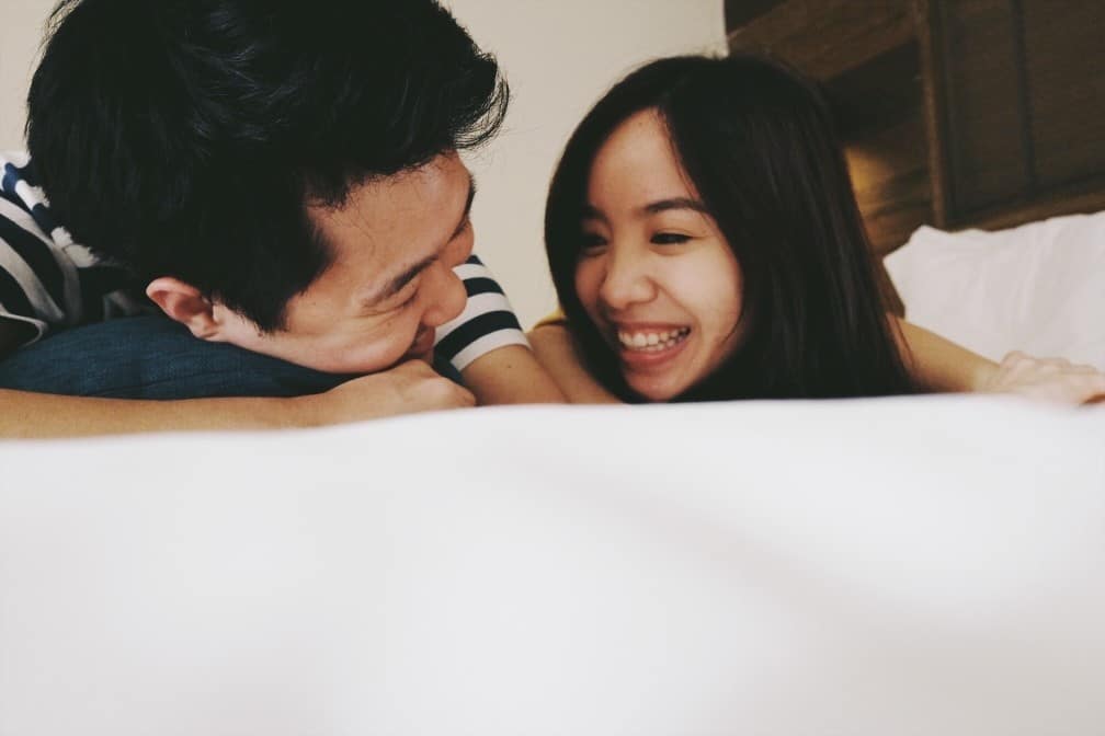 couple laughing on a bed together