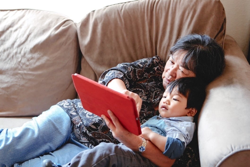 mom and son watching a tablet on the couch