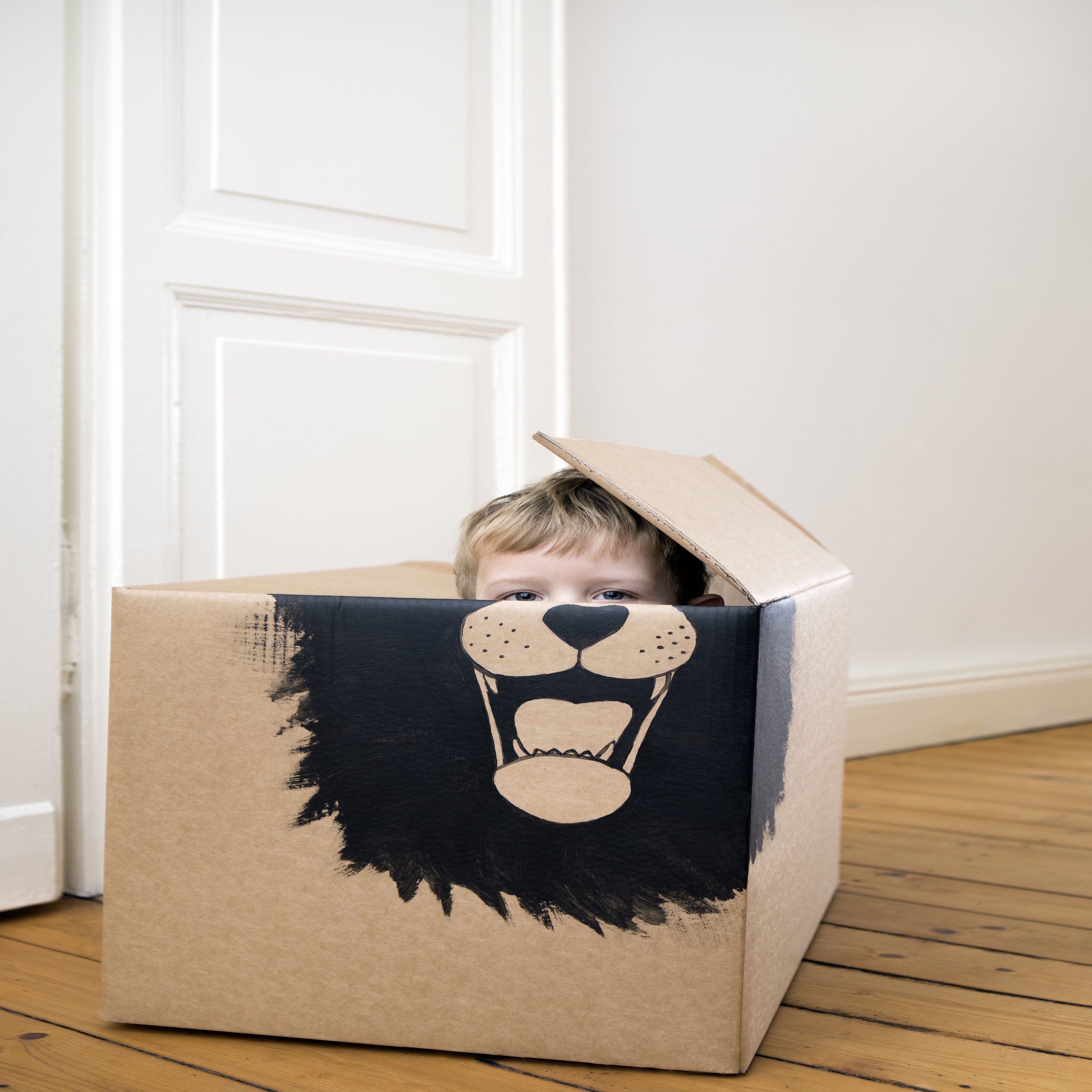 kid playing in a cardboard box