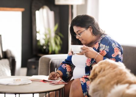 mom writing a list while drinking coffee