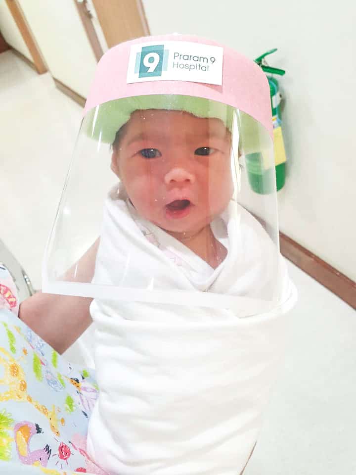 Newborn baby wears a face shield in Bangkok hospital