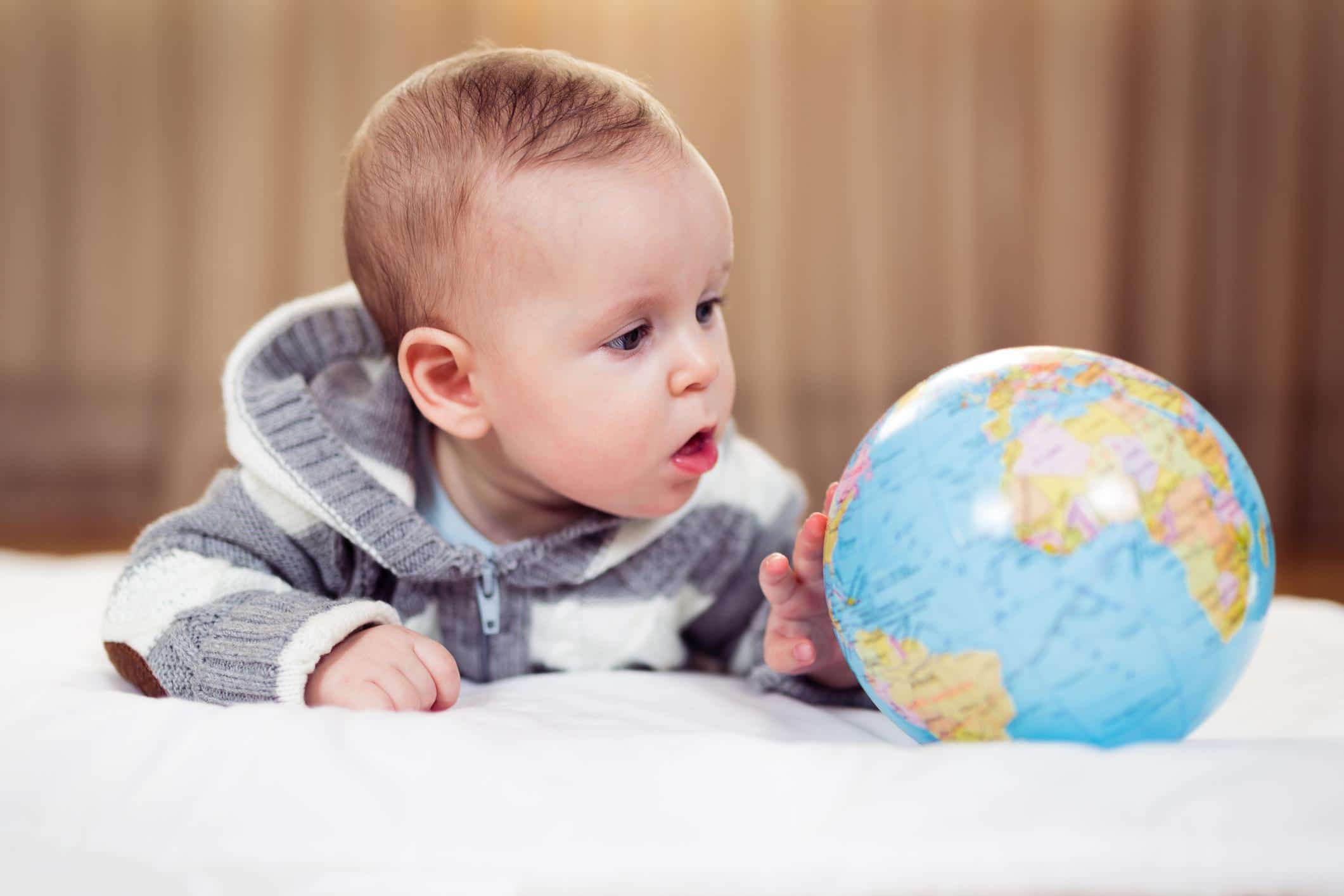 baby looking at a globe