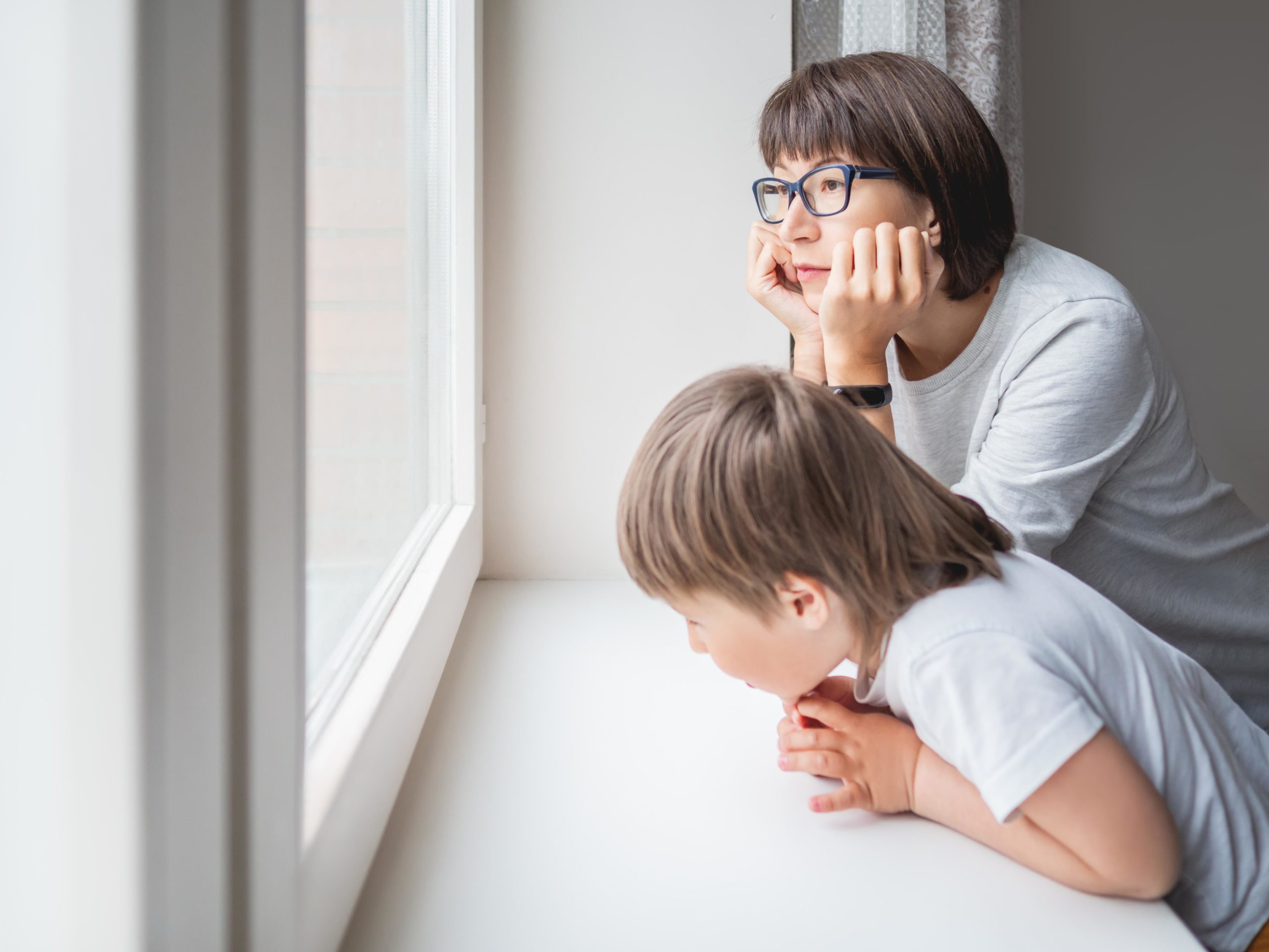 two kids looking out a window