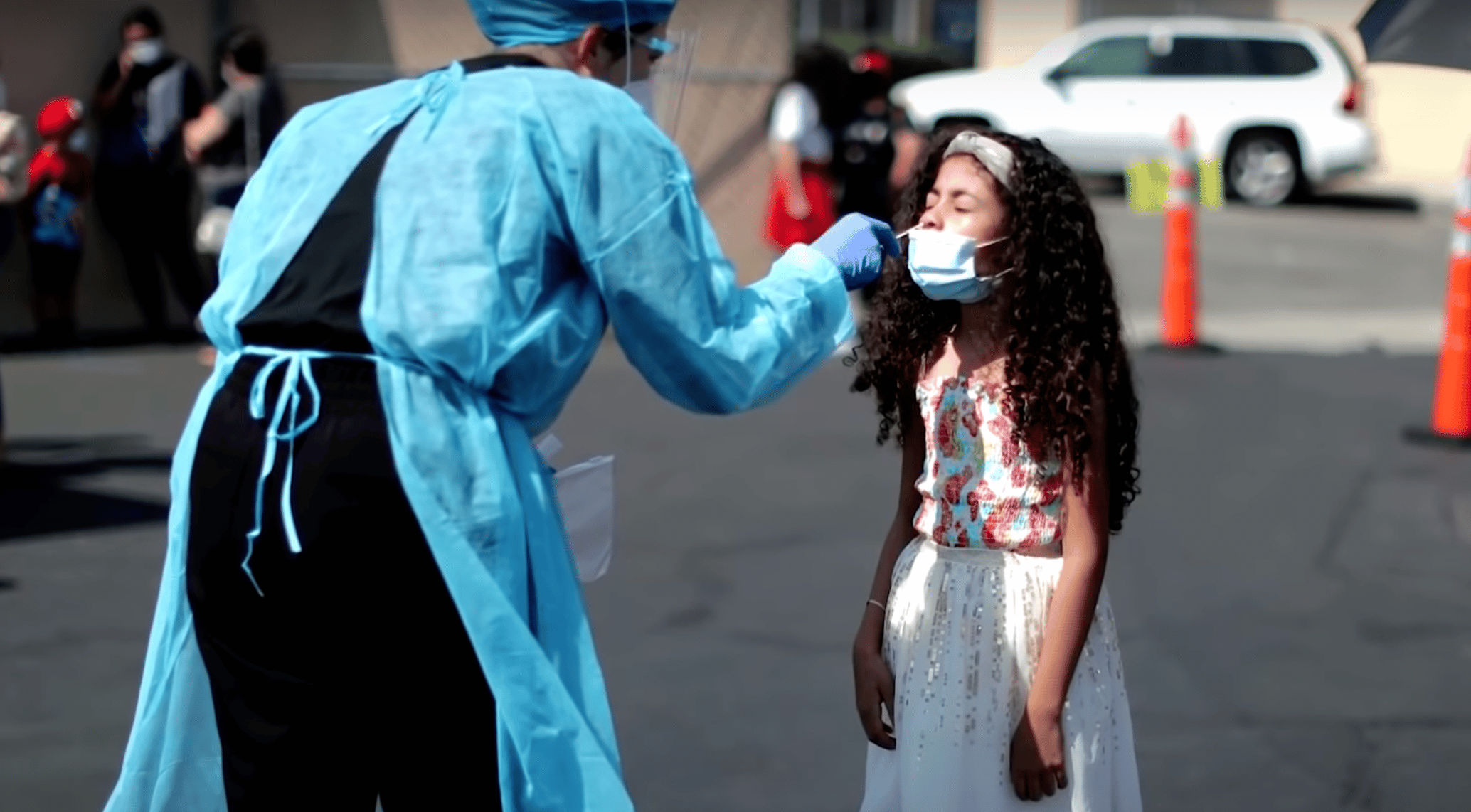 doctor doing a COVID test on a little girl