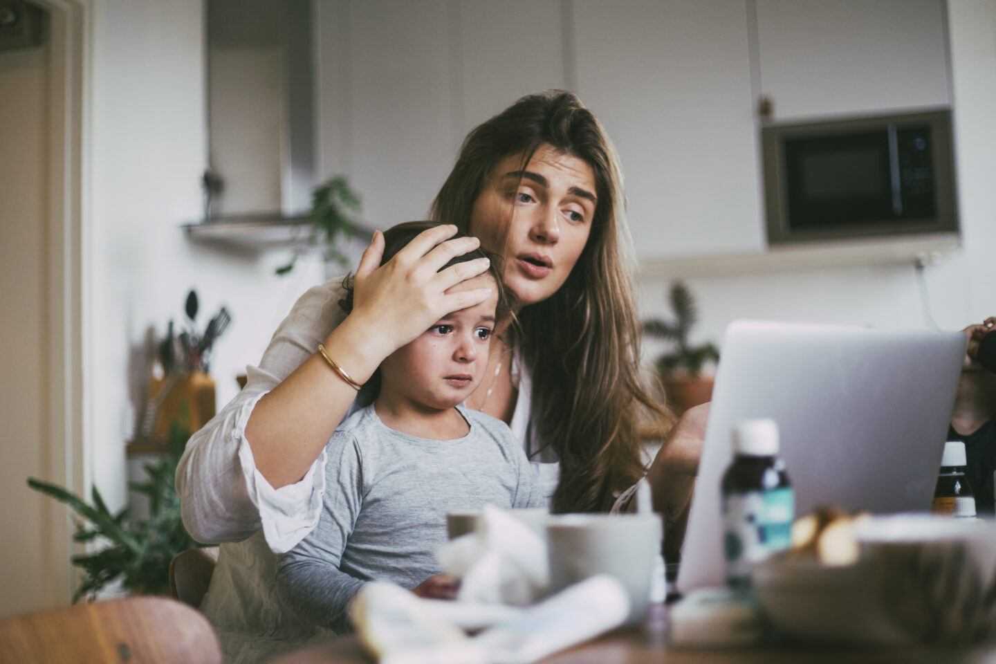 Mother with sick son taking advice on video call at home during pediatric telehealth visit