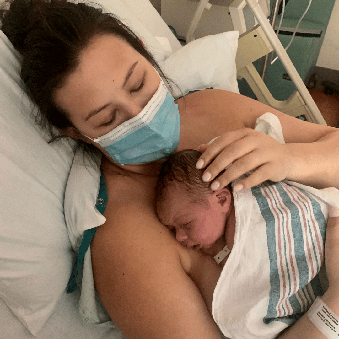 mom snuggling a baby in a hospital bed - essay on having an emergency hysterectomy after giving birth