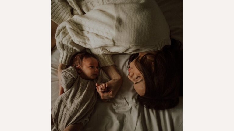 photo of mom and baby laying on a bed