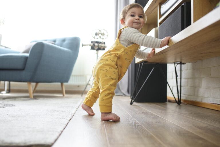 baby doesn't crawl: baby standing up and holding onto furniture