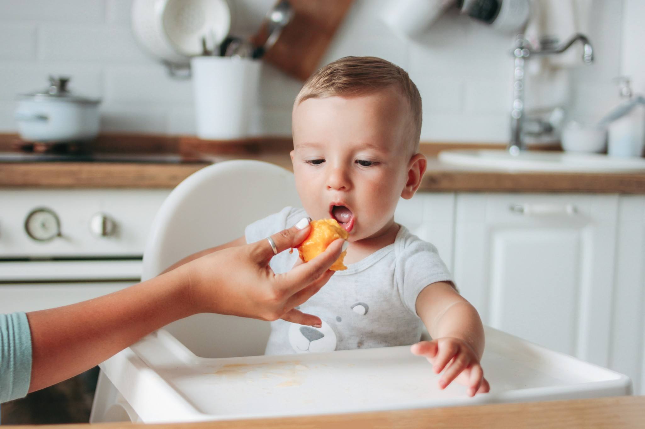 https://www.mother.ly/wp-content/uploads/2022/03/charming-little-baby-boy-eating-first-food-peach-fruit-at-the-kitchen-mom-feeds-child_t20_B8baXY.jpg