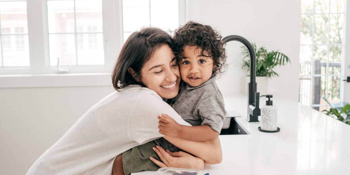 mom hugging child on kitchen counter - how to be a good mom