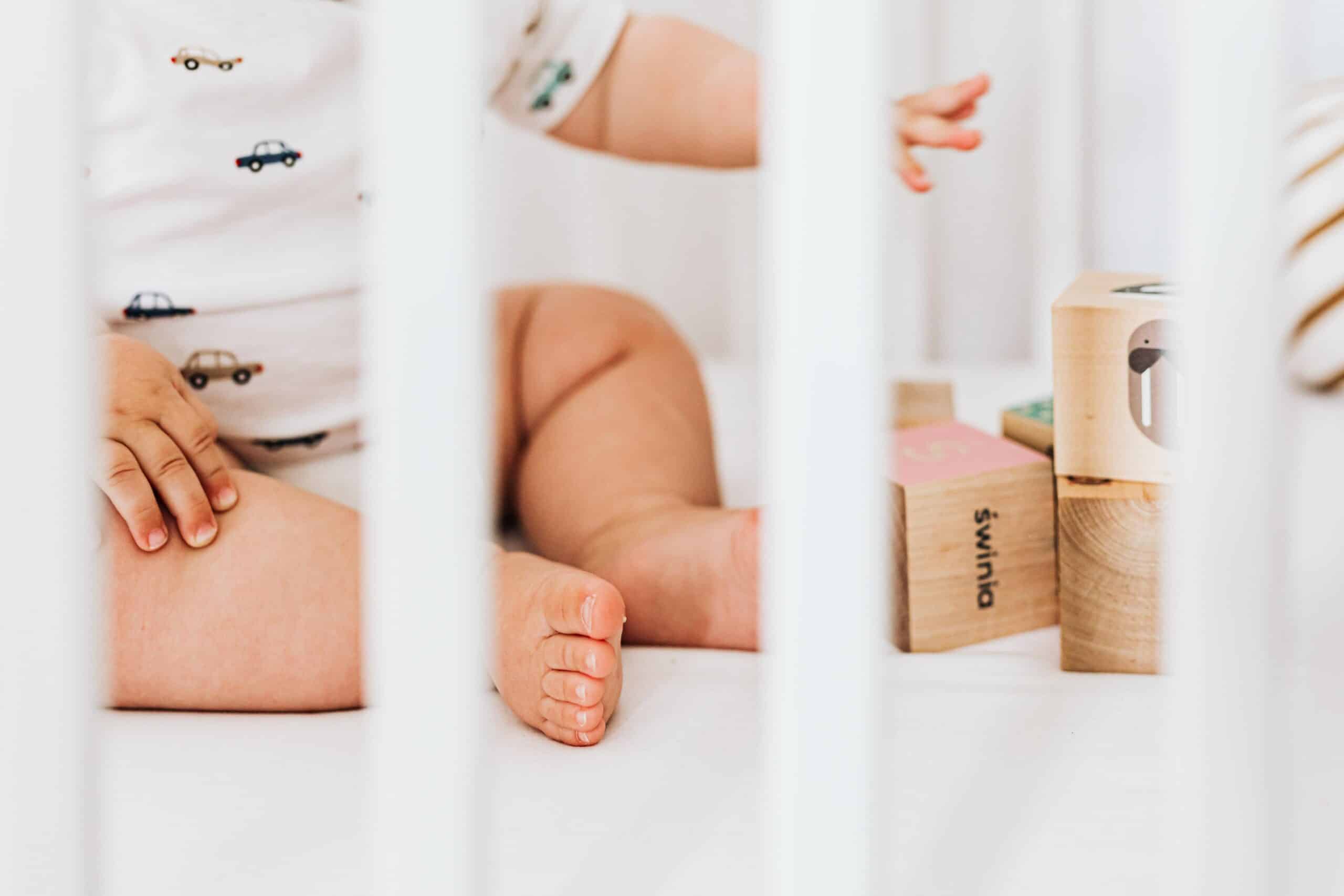 https://www.mother.ly/wp-content/uploads/2022/07/baby-toes-in-a-crib-with-blocks-scaled.jpg