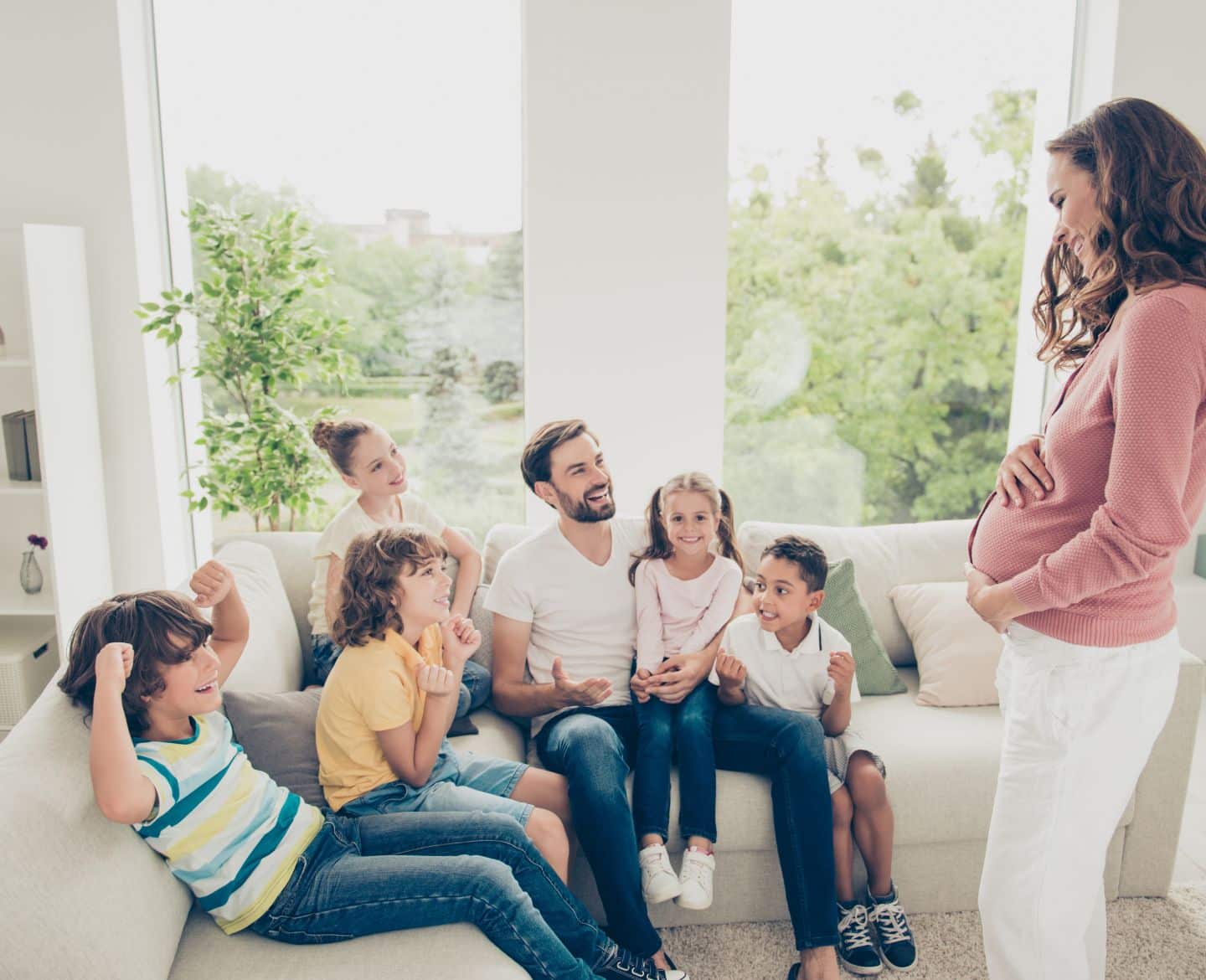 pregnant wife, husband and five kids sitting in living room