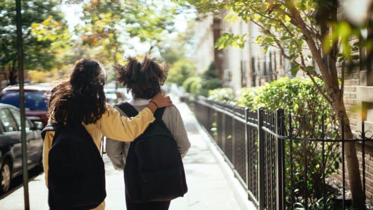 two kids walking to school wearing backpacks do bulletproof backpacks work Motherly