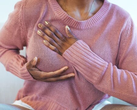 woman performing a self breast exam Motherly