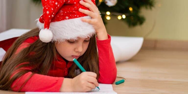 little girl in front of christmas tree wearing santa hat coloring- christmas coloring pages