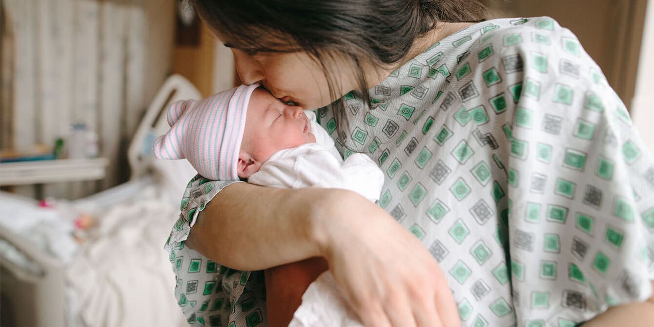 https://www.mother.ly/wp-content/uploads/2022/10/mom-kissing-newborn-baby-in-hospital-gown.jpg