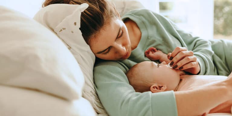 mom laying down with her newborn - how to stop contact naps