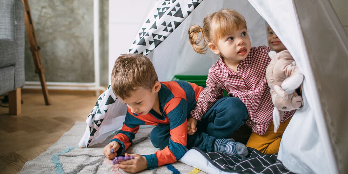 siblings playing in tent showing what it's like having a sibling with down syndrome