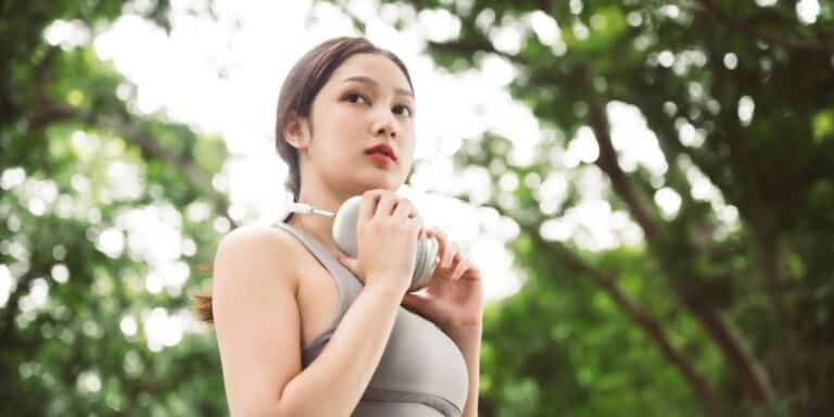 woman going for a walk with headphones wearing a sports bra though recent report found high levels of bpa in sports bras